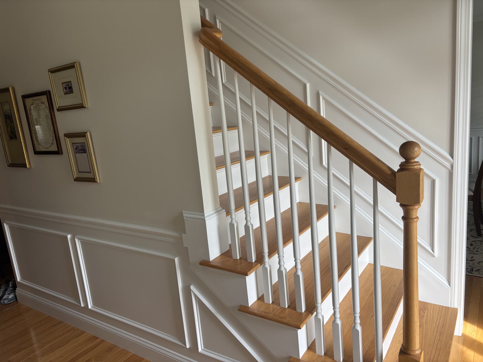 Finished staircase with oak rail and painted wainscoting