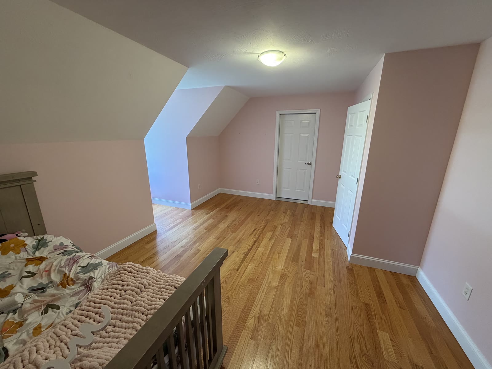 Finished pink bedroom with vaulted ceiling