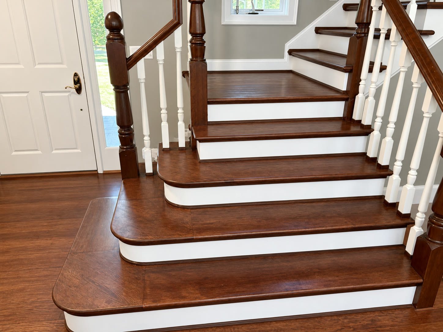Refinished staircase and entry hall with stained treads and painted white risers
